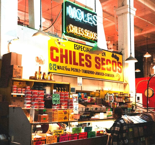 Mujer comprando en una tienda mexicana llamada Moles que vende Chiles SECOS